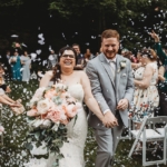 Newly weds walking down the aisle through a confetti shower