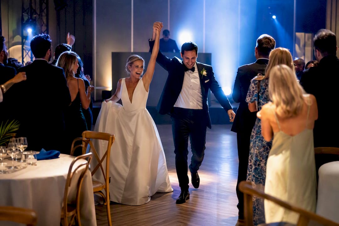 Couple making a lively wedding reception entrance