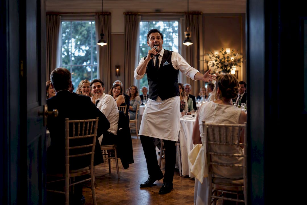Singing waiter surprising wedding reception guests