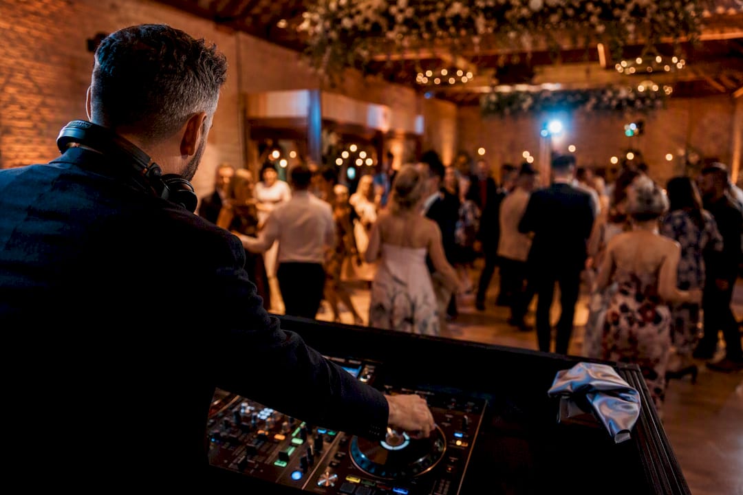 Wedding guests dancing as DJ cues music