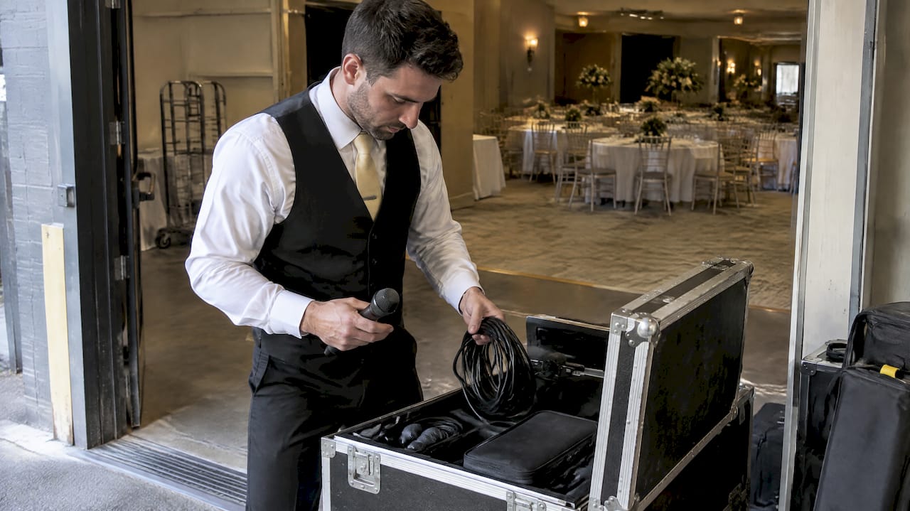 Singing waiter preparing event equipment