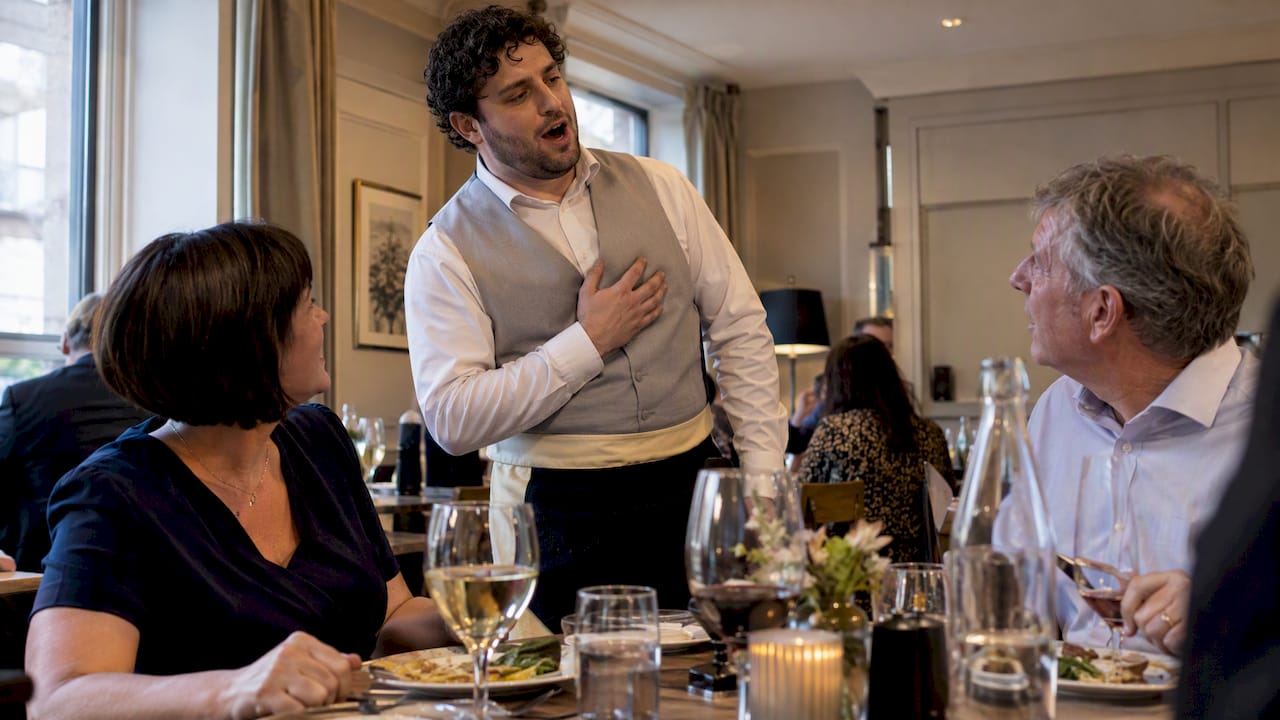 Singing waiter surprises guests during dinner